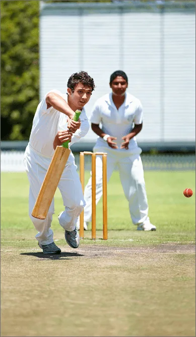 Two junior cricketers – a batter and a wicket-keeper – at the stumps
