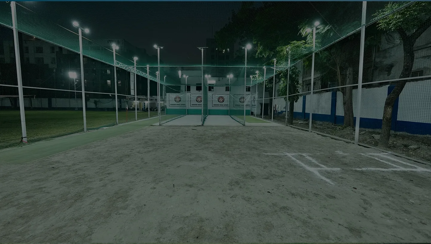 Harvard House Sports indoor practice nets lit at night