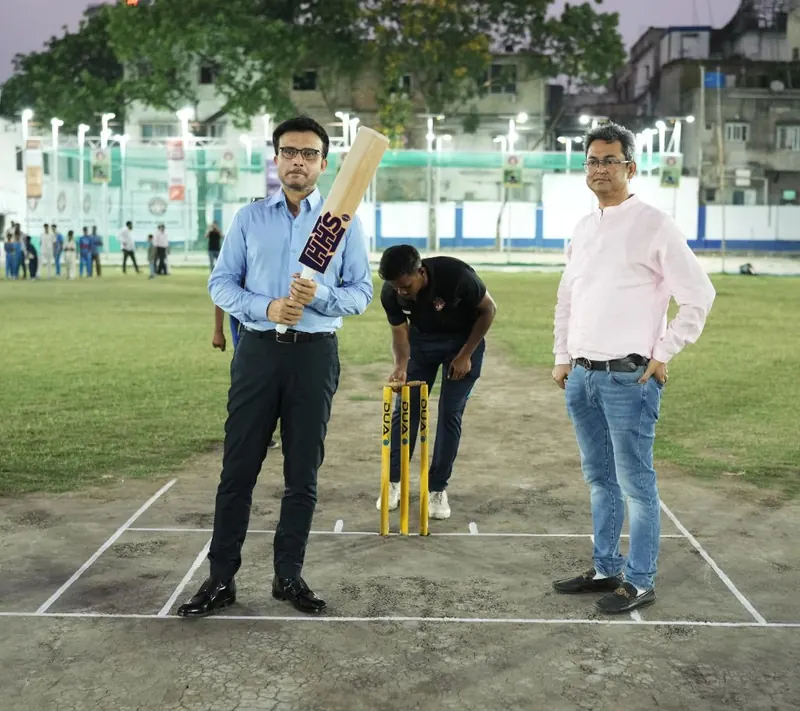 Sourav Ganguly holding an HHS bat on the Harvard House Sports pitch under floodlights