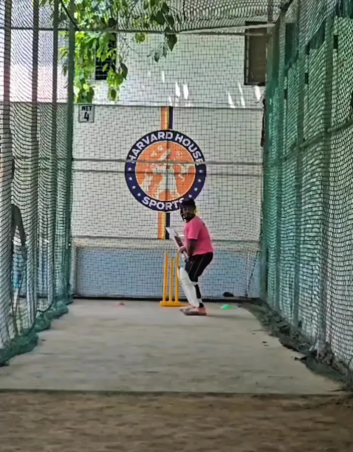 Batter in the indoor nets in front of the HHS logo target