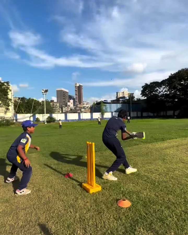 Junior batter driving on the outfield under a blue sky